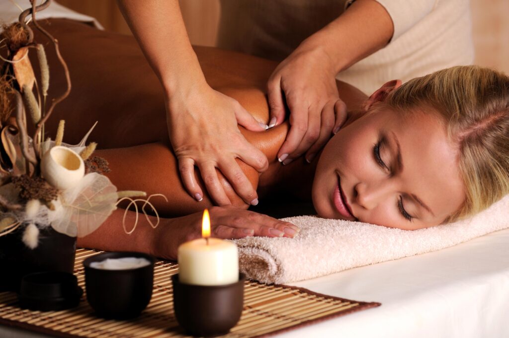 Women receiving a shoulder massage from a masseur.