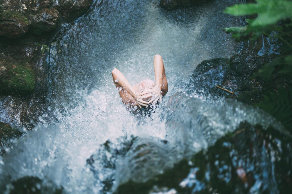 women showering under a natural waterfall